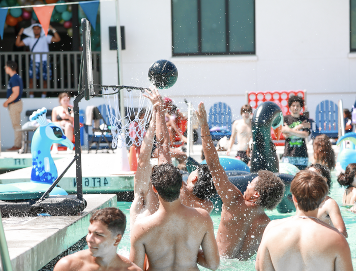 Hoop it up: First years gather in the shallow end to play pick-up basketball in the pool during the Weekend of Welcome Pool Party on August 24, 2024. / Photo by Ashleen Rai ’26